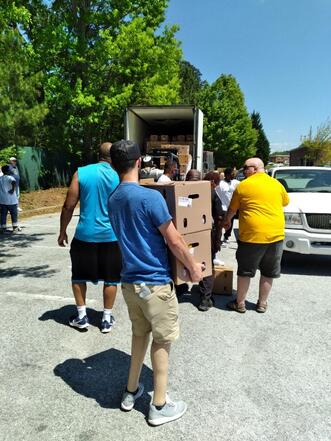 Picture of Lions loading a truck od boxes to deliver items to people in need.