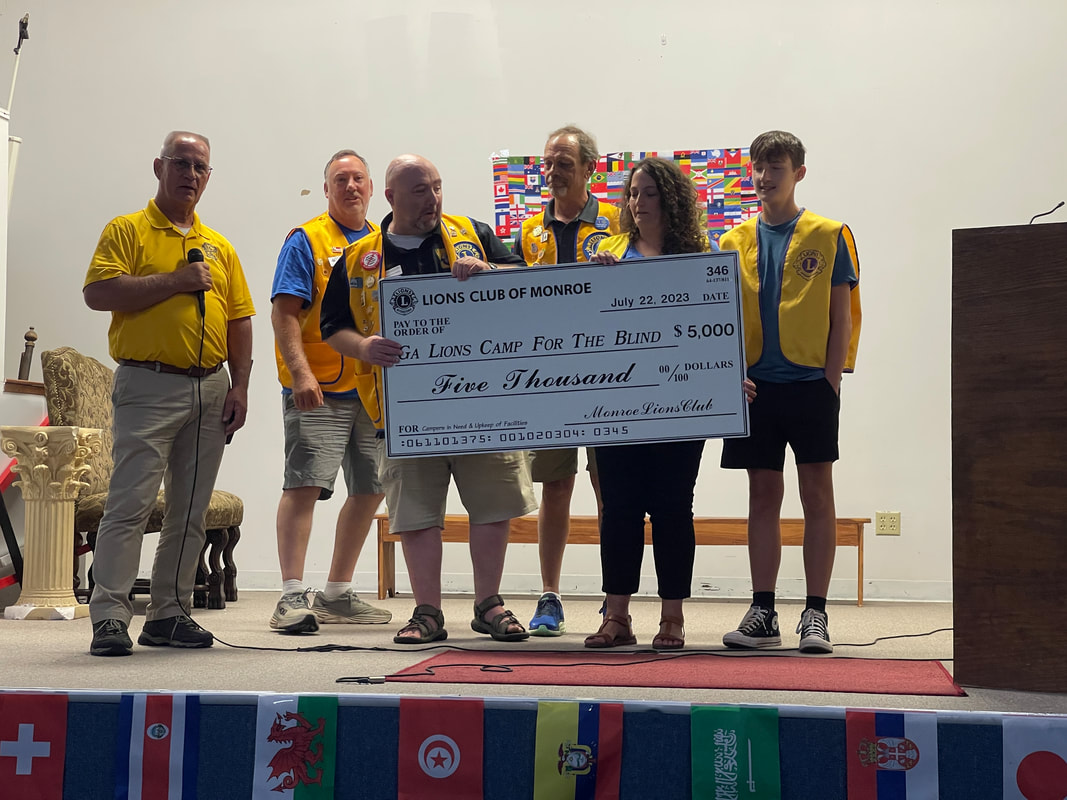Picture of the Monroe Lions Club handing a  $5,000 donation check to the Georgia Lions Camp